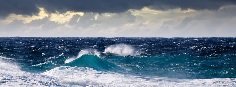 How do ships minimize the rocking from rough seas?